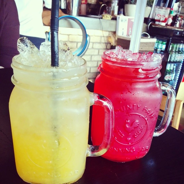 two colorful mason jars hold cold beverages