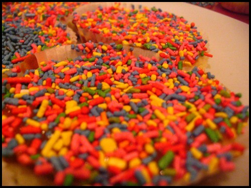 a doughnut sprinkled with colorful sprinkles sitting on a table