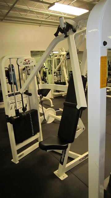 a gym with two row machines and some bars