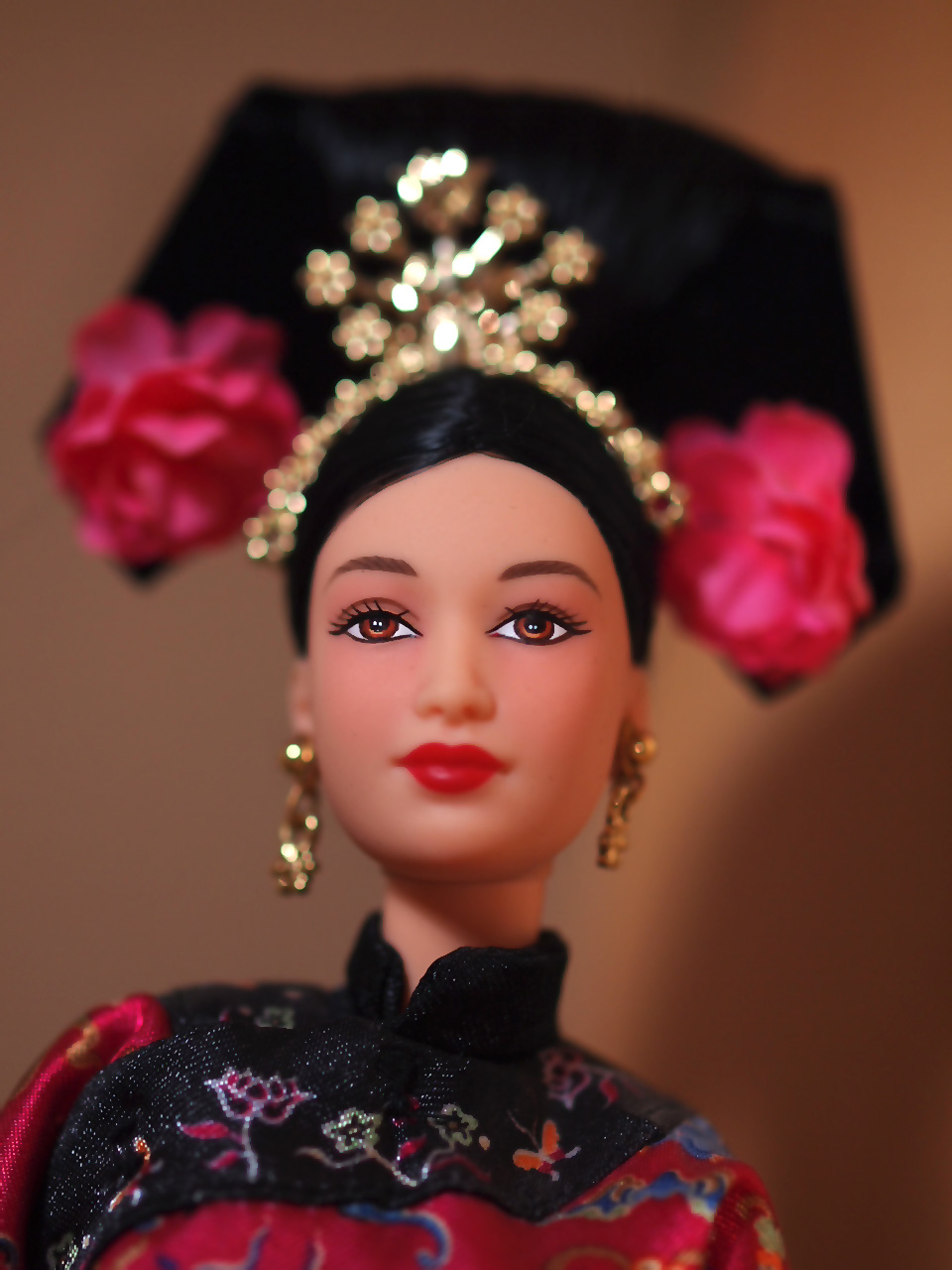 a dolls face wearing a chinese style dress and a black and gold headpiece