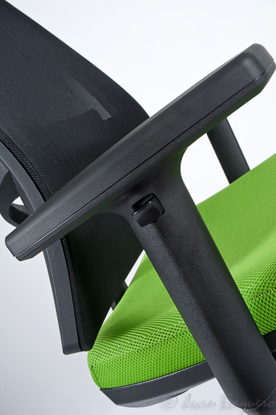 a green office chair with dark wood frame