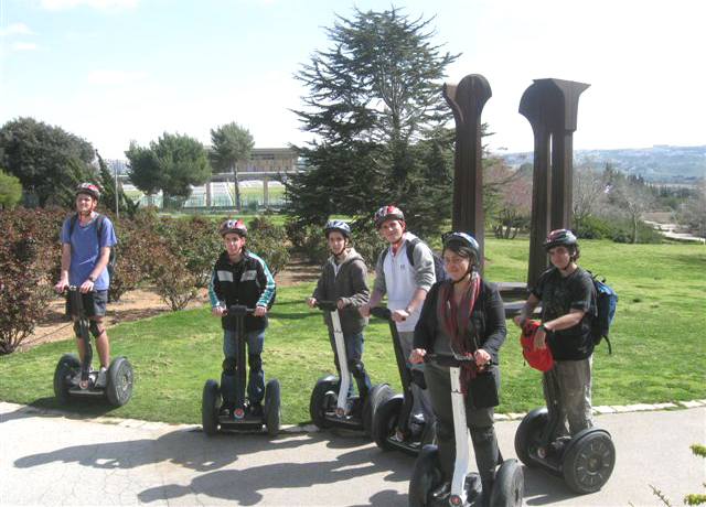 a group of children and adults riding segways outside