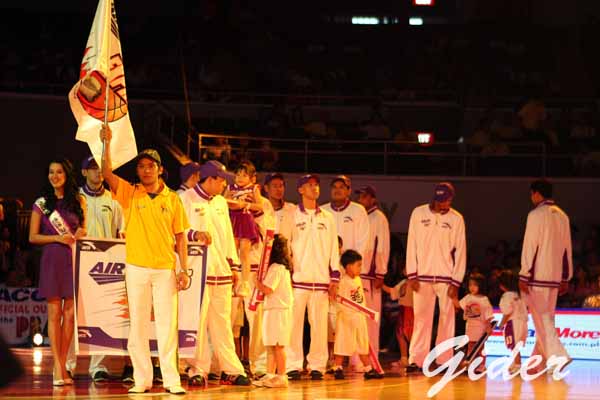 a group of men on a basketball court holding flags
