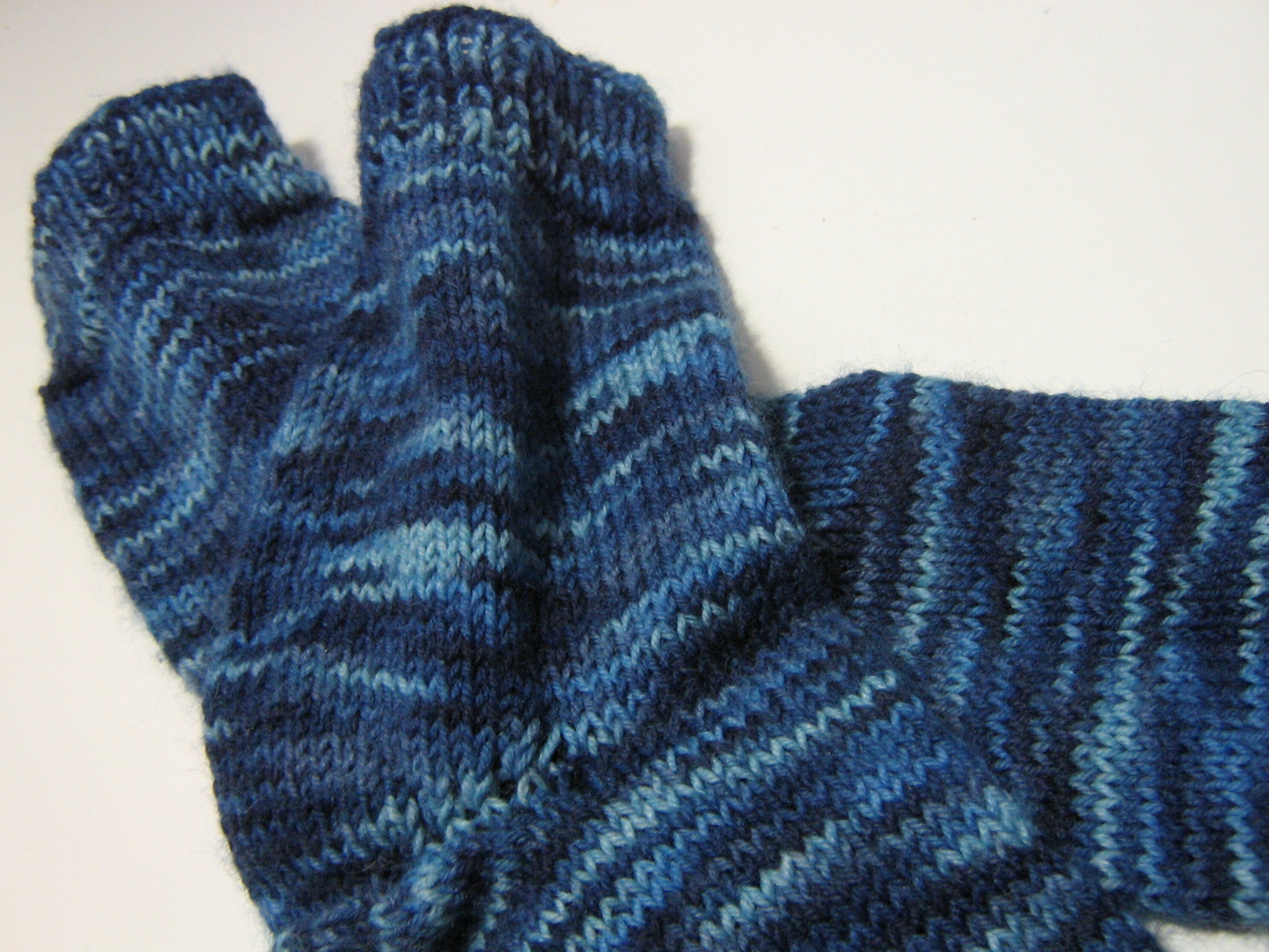 a pair of blue mittens laying on top of a white surface