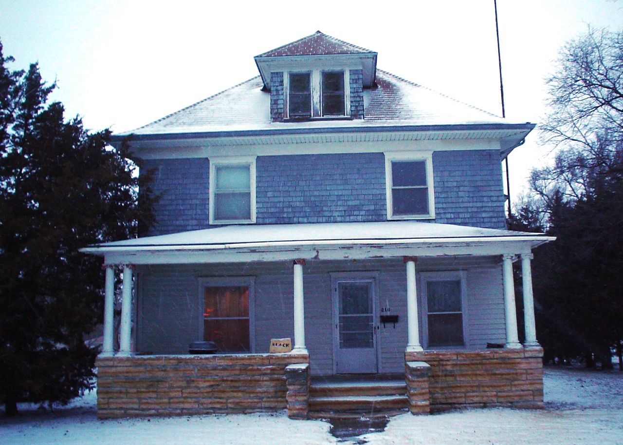 a gray house with white trim on the windows and shutters