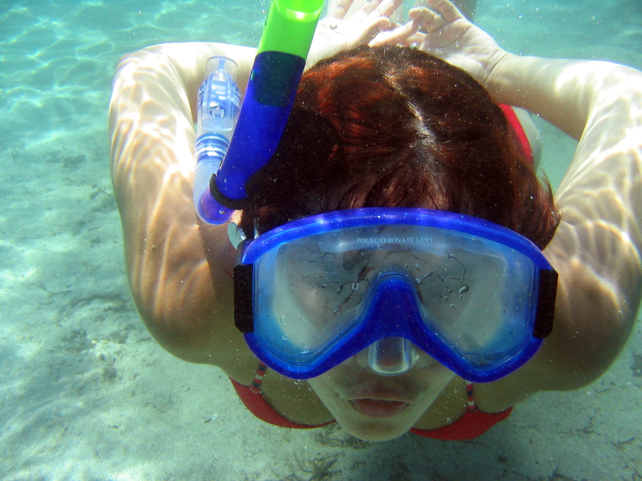 a woman is swimming with snorng mask and snorls