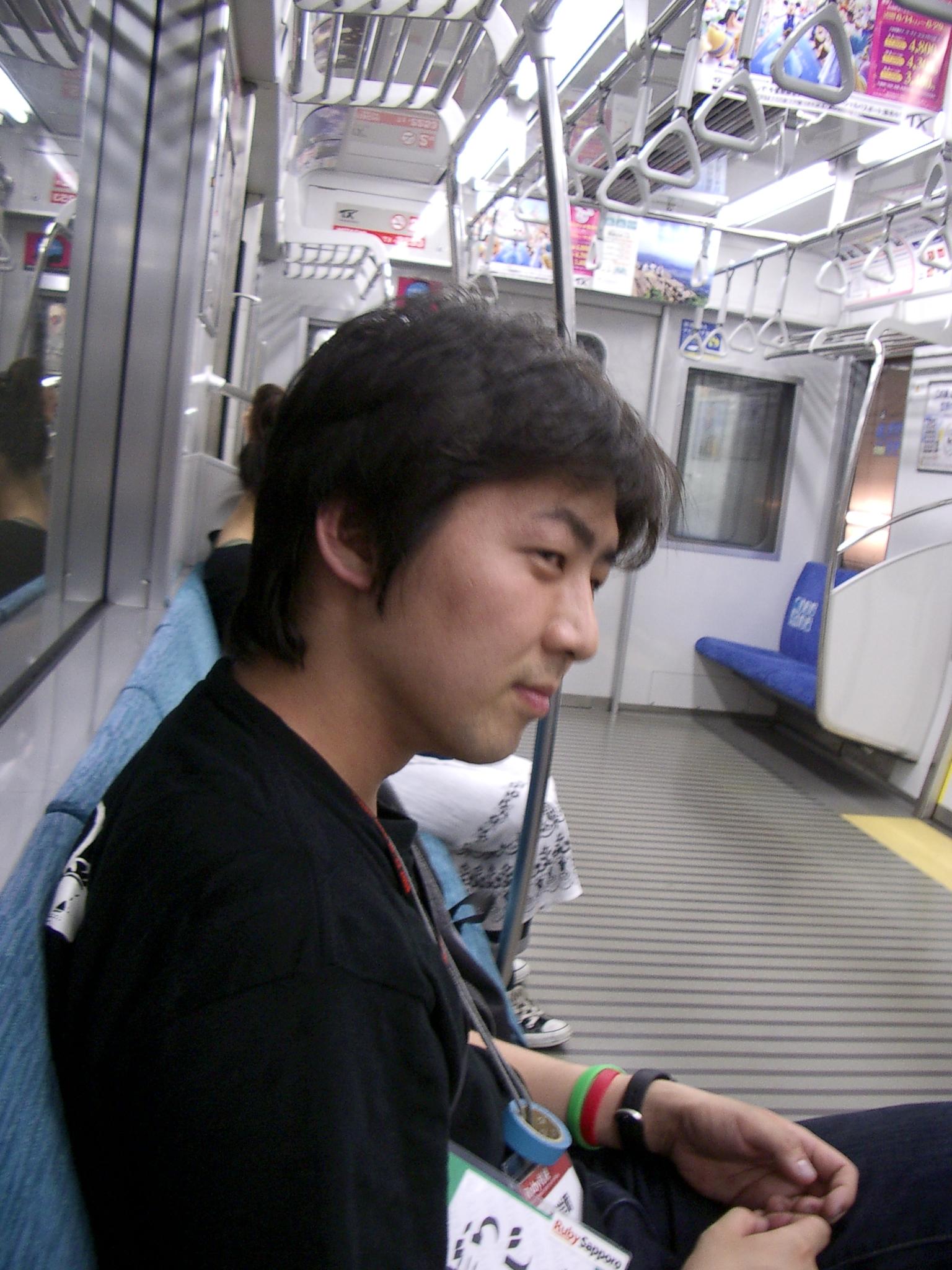 a man in black shirt sitting on the subway
