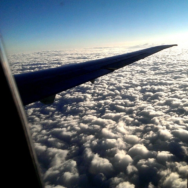 an airplane wing is seen through the clouds