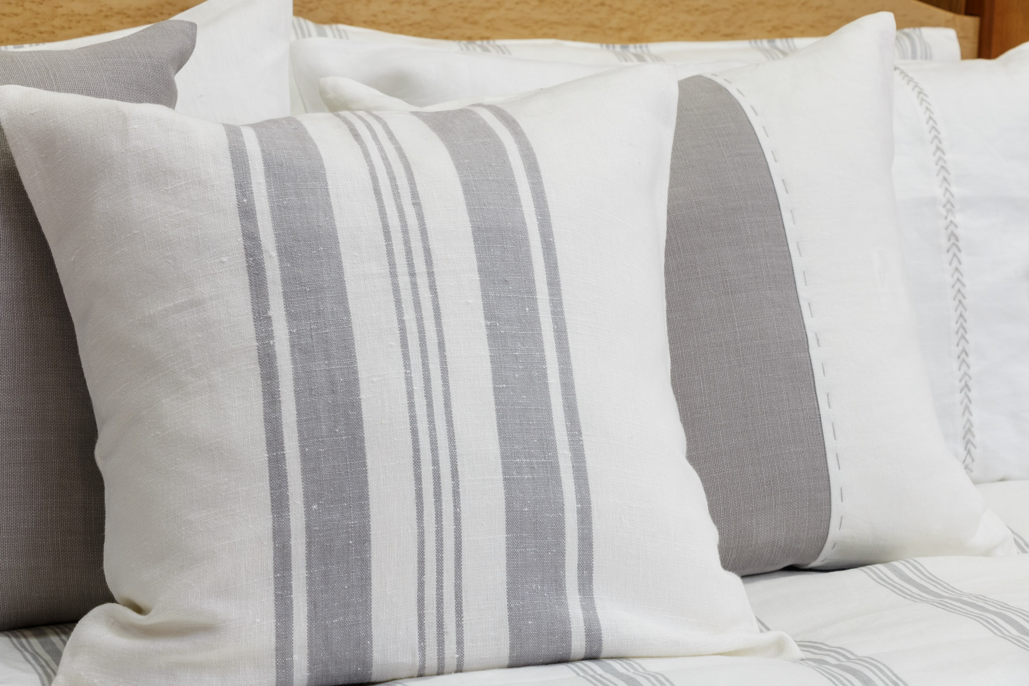 three different striped pillows sitting on a bed