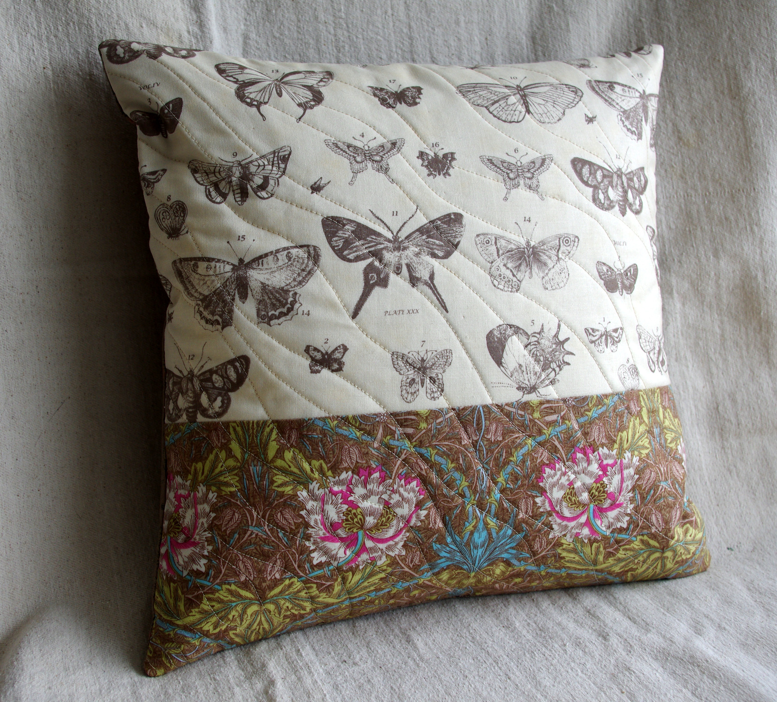 a erfly and flower themed quilted pillow is shown