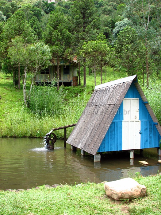 a small boat house in a body of water