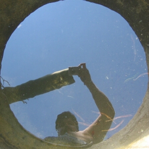man taking a selfie out of a sewer