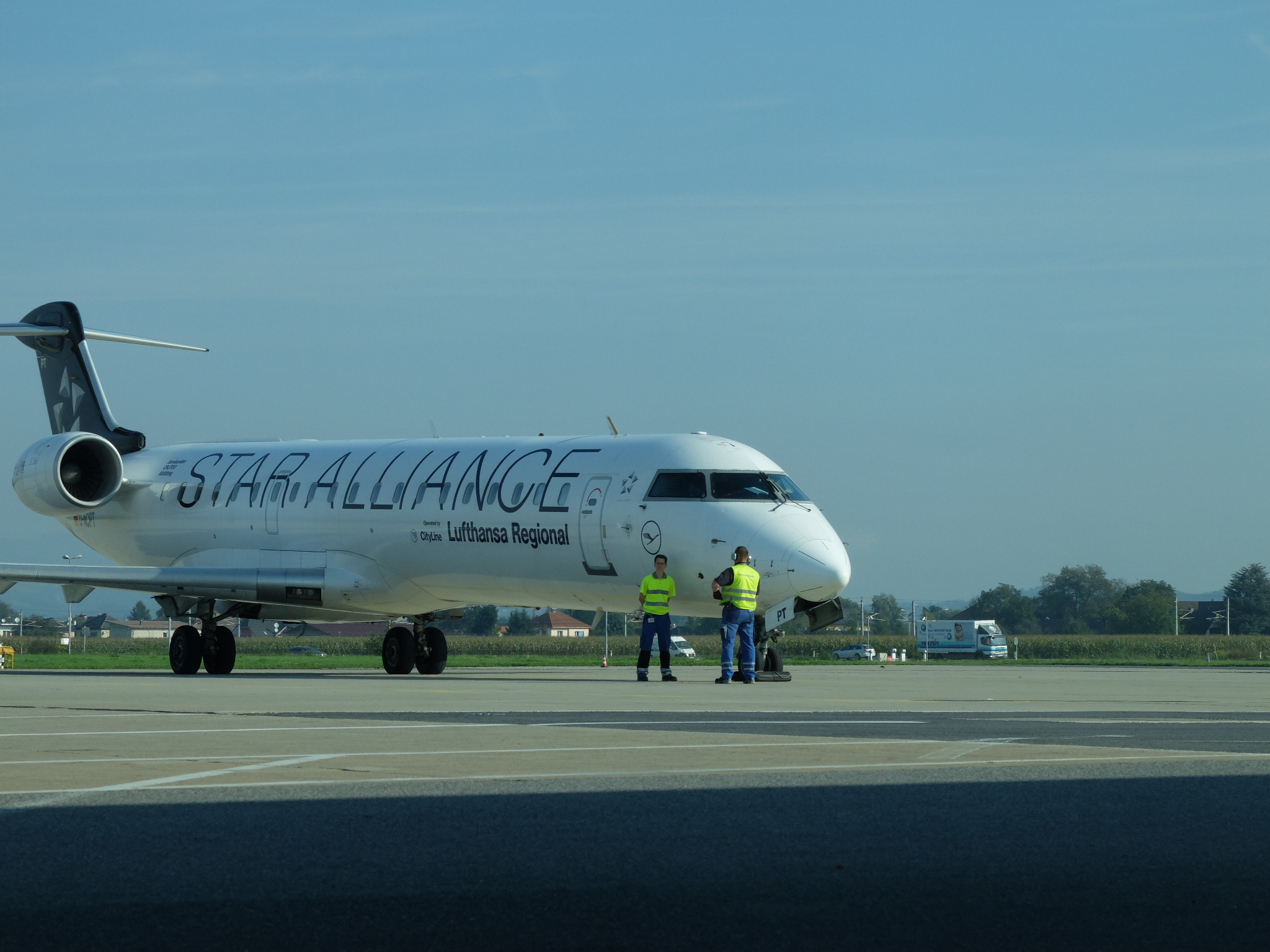 some men are on the runway next to an airplane