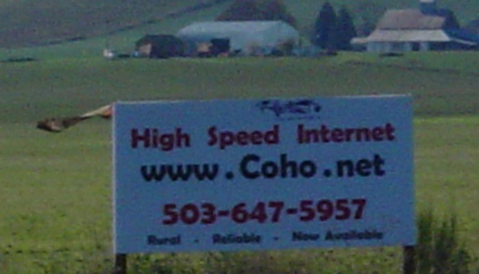 a sign that is in front of a grassy field
