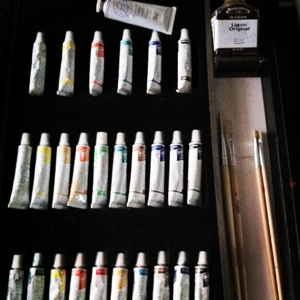 a case filled with white paint tubes and papers