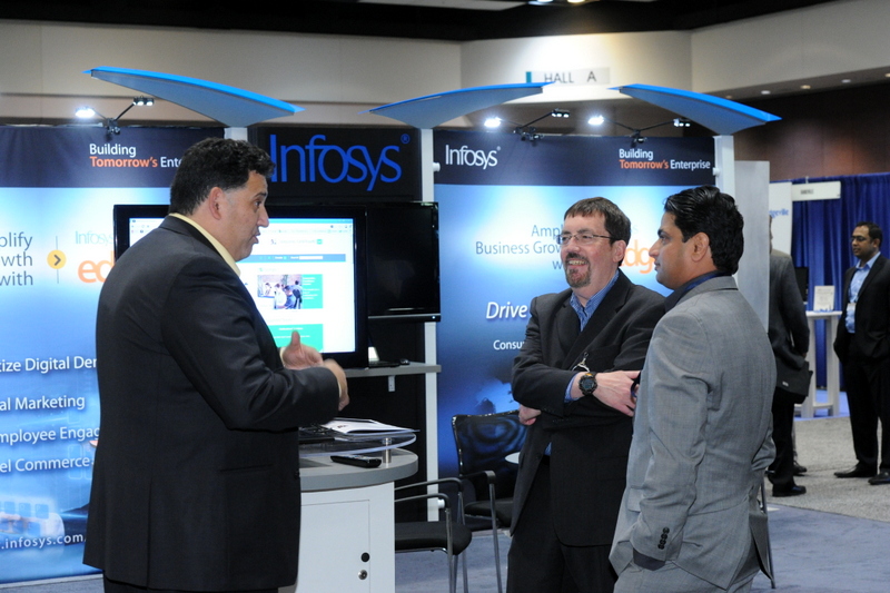 three men discussing a company booth display