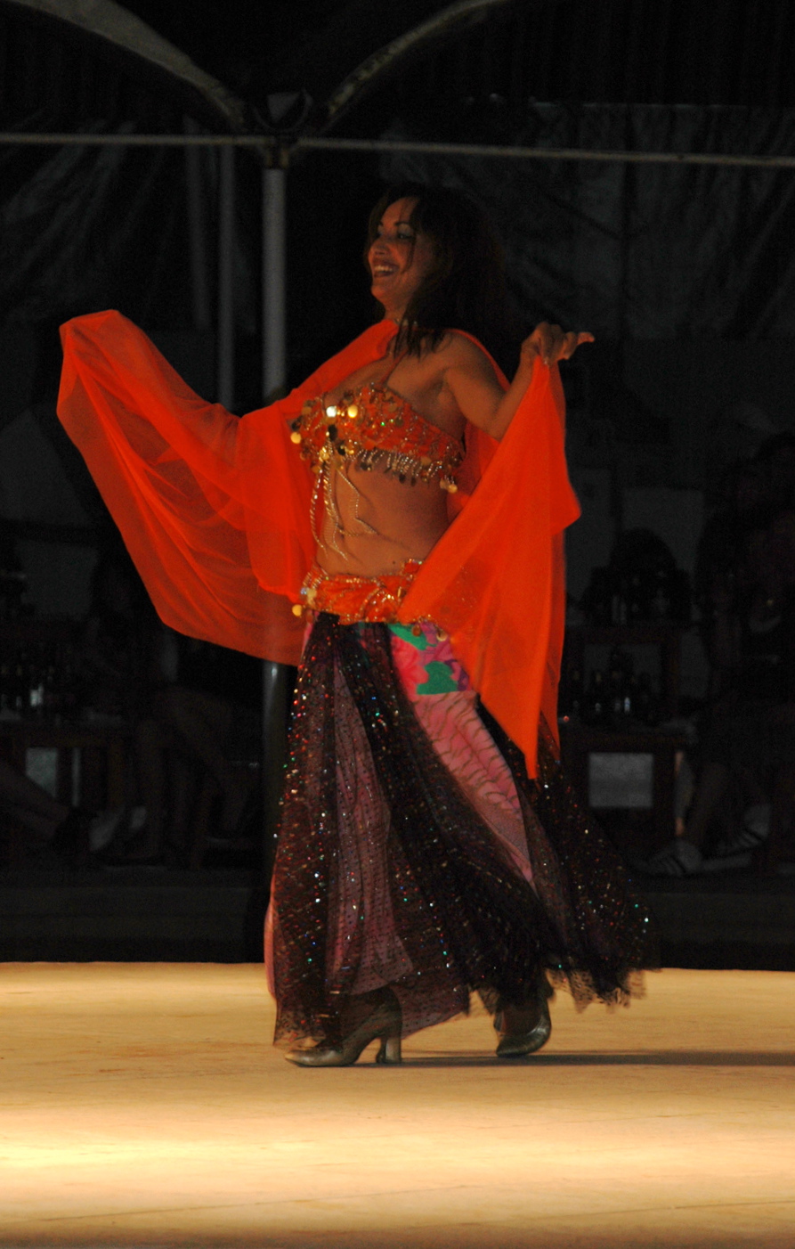 a belly dancer in red is doing soing in her hands