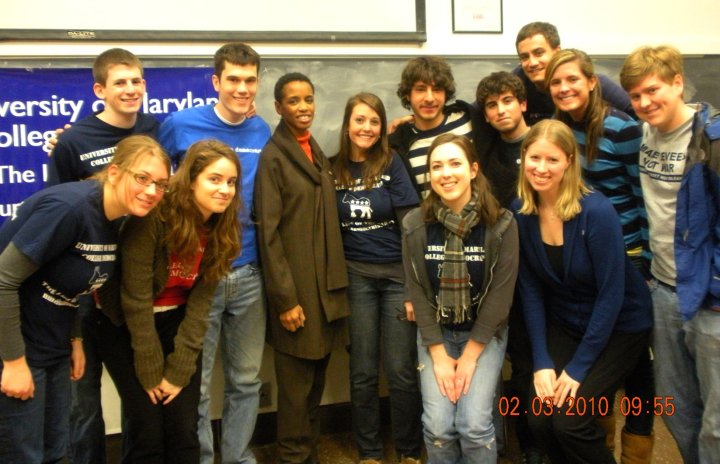 a group of students are posing in front of a sign