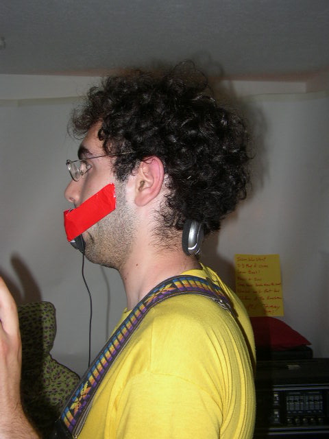 a man with a taped face holding an object in his mouth
