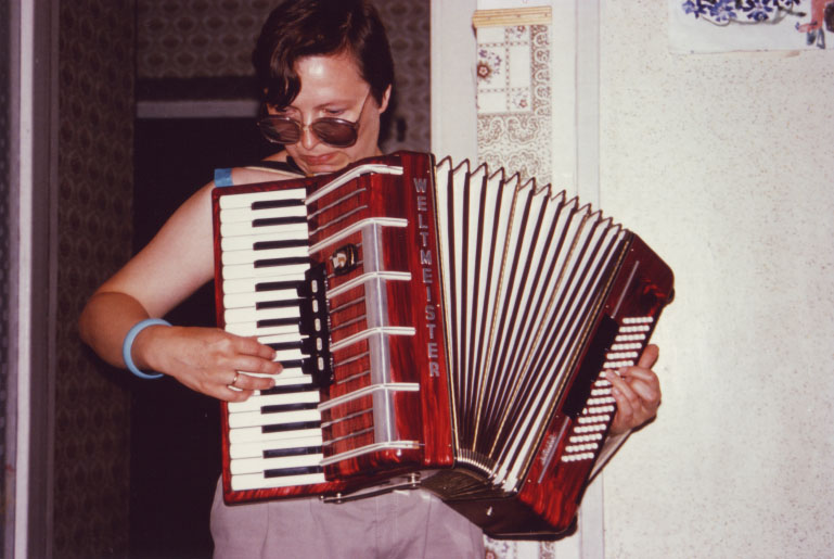 a man holding an accordion playing the keyboard