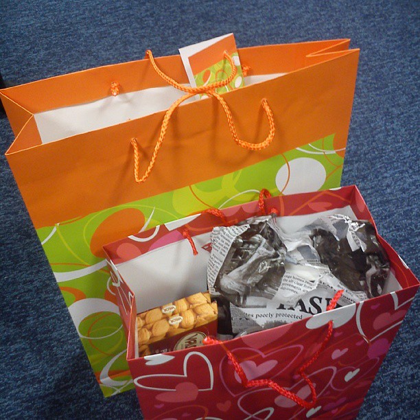 large orange, green, red, and blue shopping bags filled with candy and candies