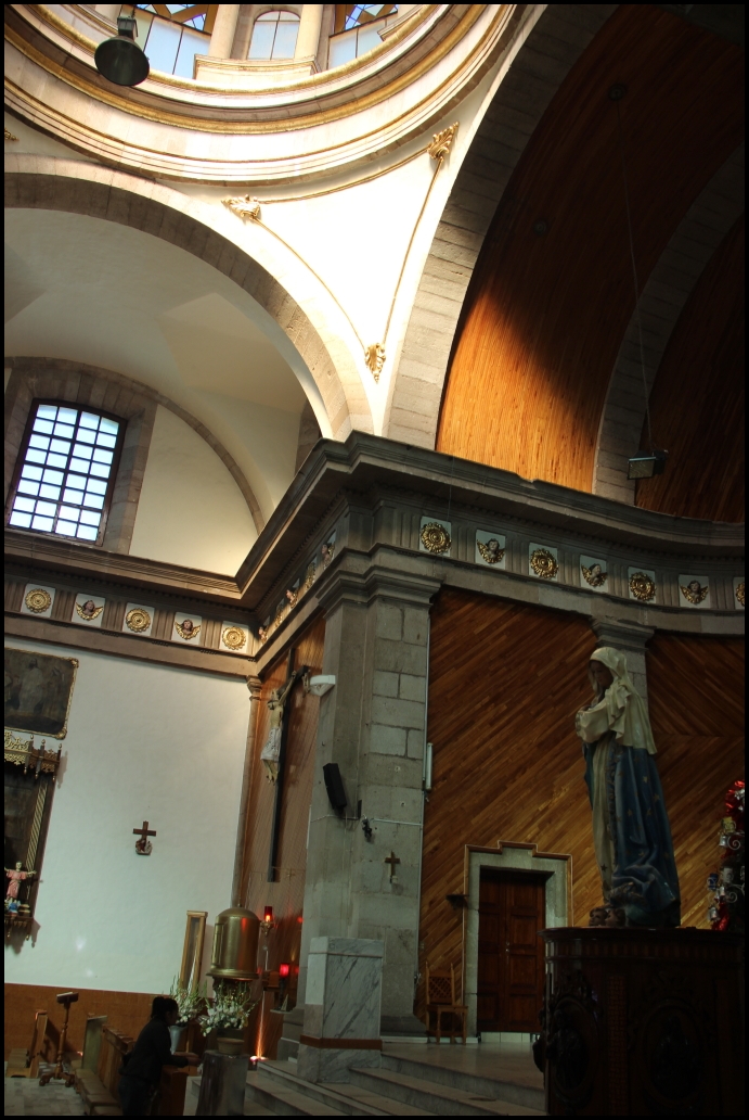 an empty church with a statue of jesus in it