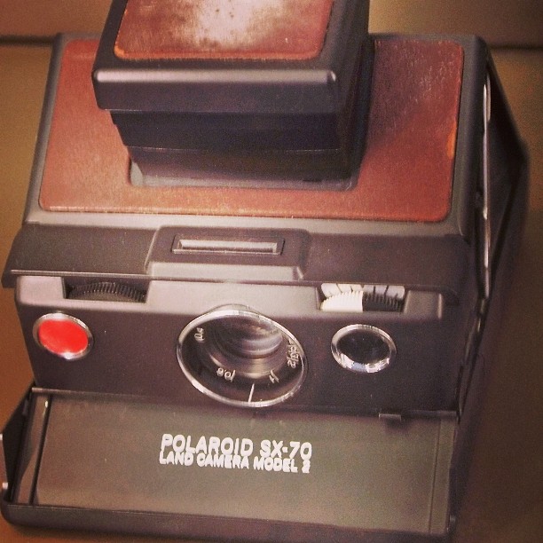 a polaroid camera sitting on top of a wooden desk