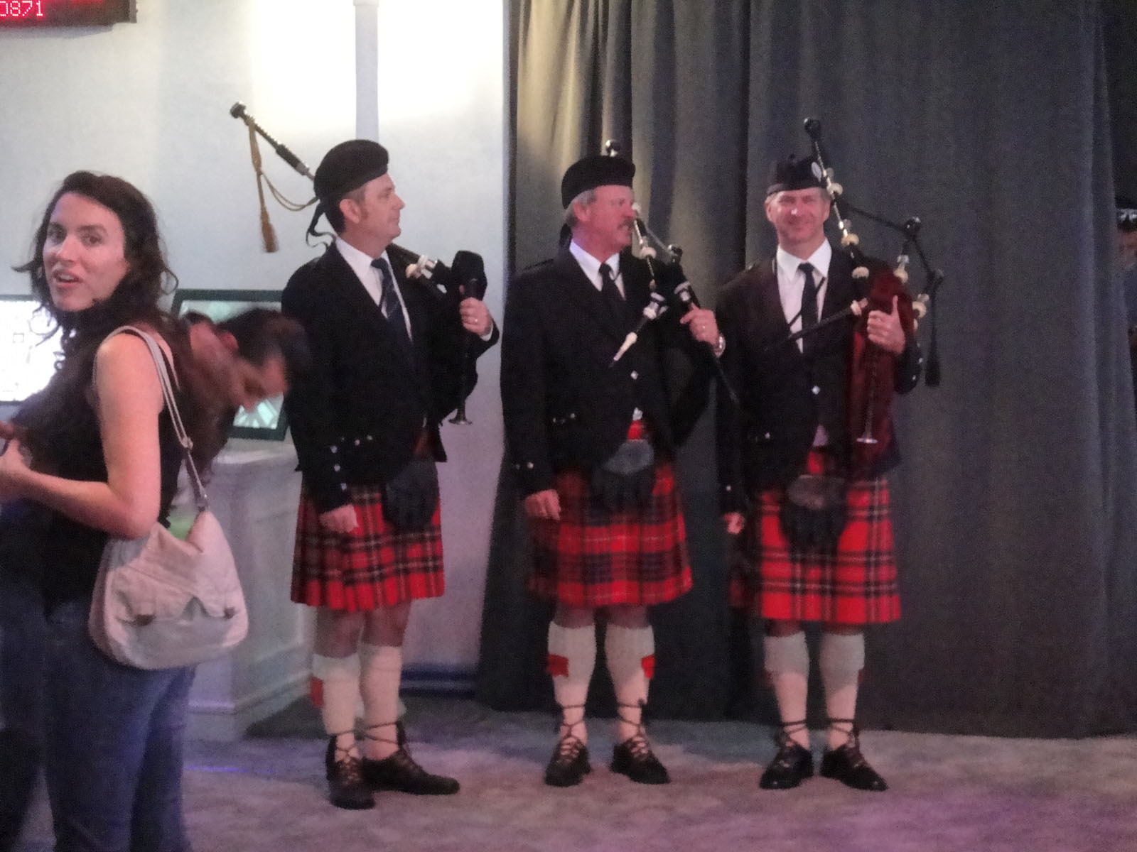 three women are dressed in a uniform with pipes, and three men are wearing kilts