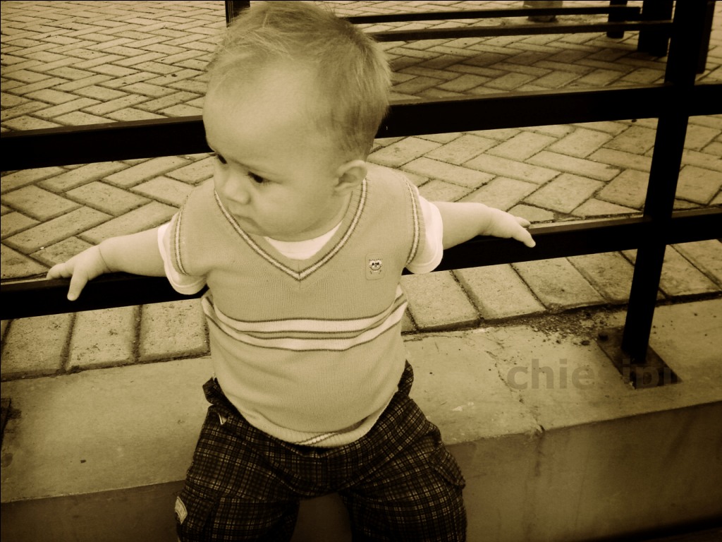 a baby is standing outside with his arms outstretched