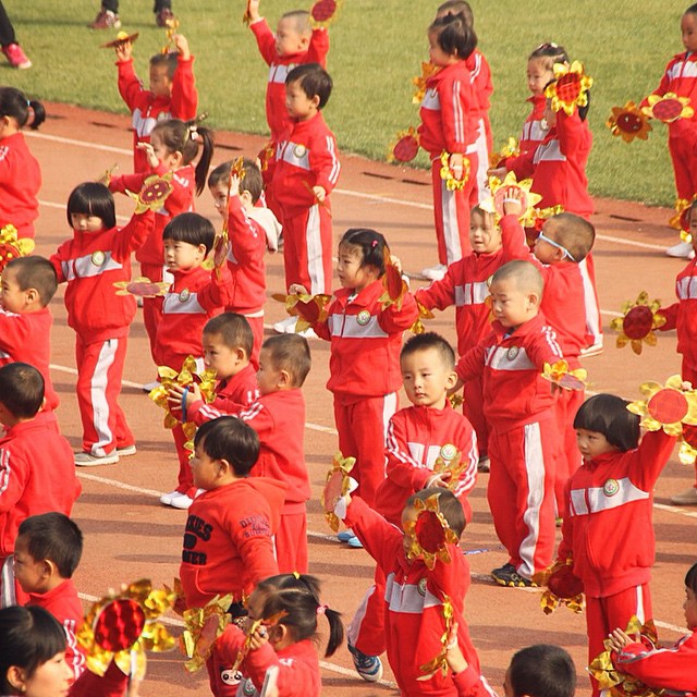 a group of children marching on a race track