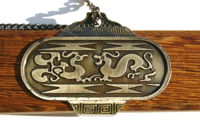a metal door handle with designs in a wood and iron frame