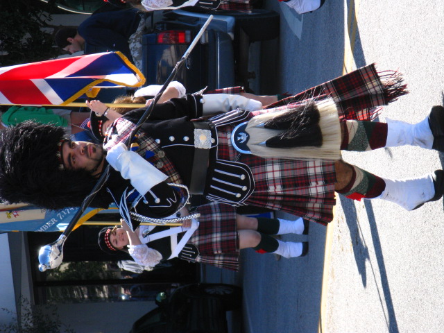a man in a kilt is marching down the street