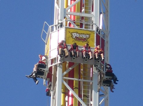 people ride on an amut ride during a sunny day