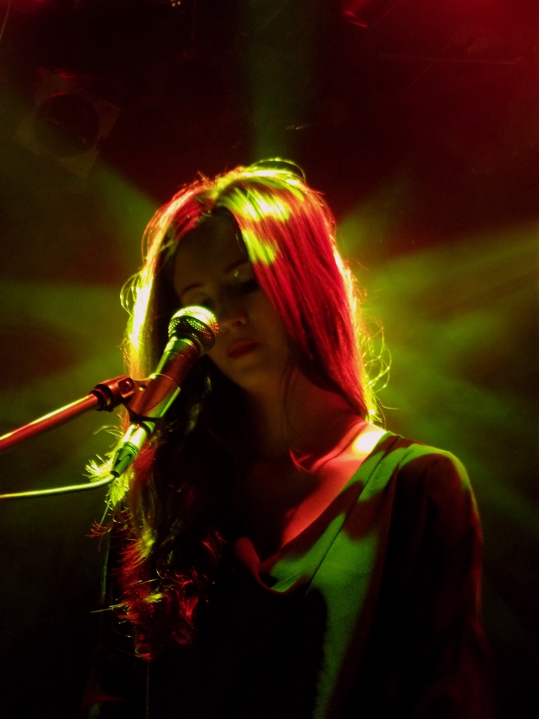 a young lady that is on stage singing into a microphone