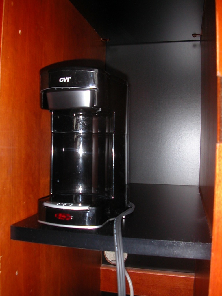 a coffee maker on the counter of a tiny apartment