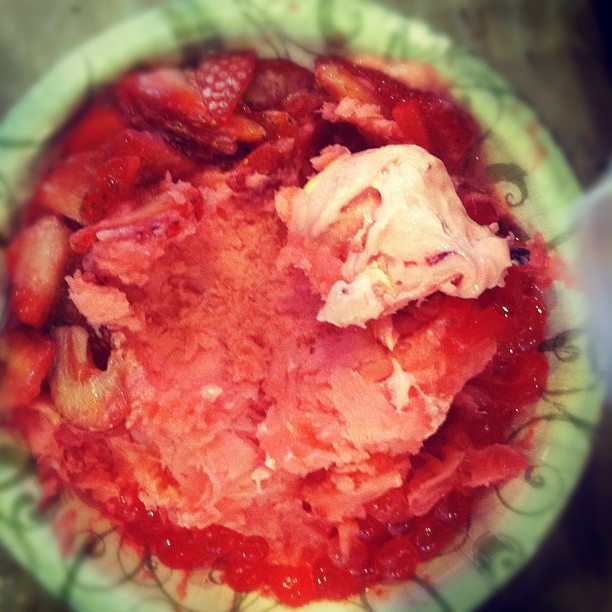 a bowl with a pink substance in it sitting on top of a wooden table