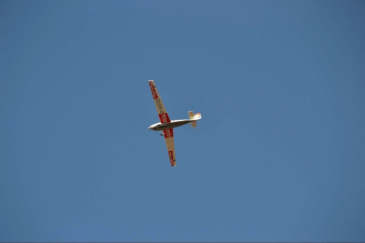 a red and white airplane flies in the blue sky