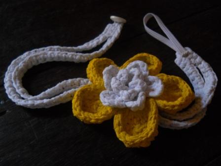 several knitted flowers and cords on a table