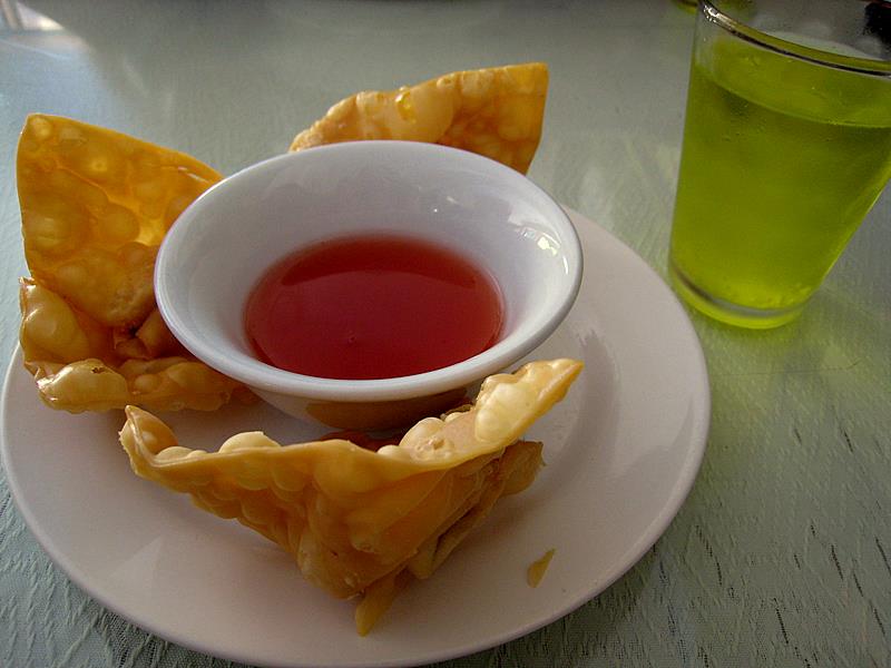 a cup of tea and some chinese dumplings on a plate