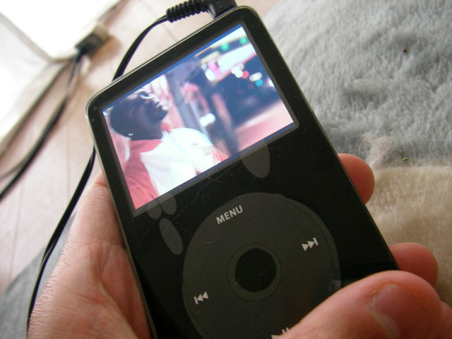 a hand holding an ipod in a display screen