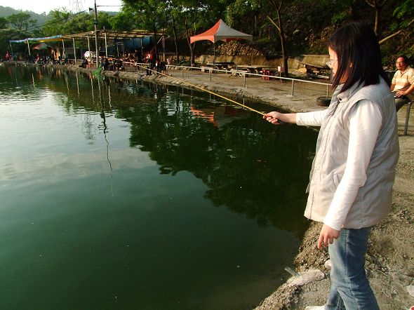 a woman fishing in a lake by herself