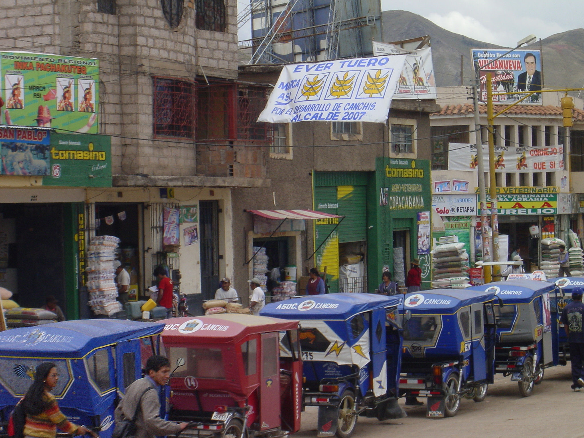 a group of small cars sit in the middle of the street