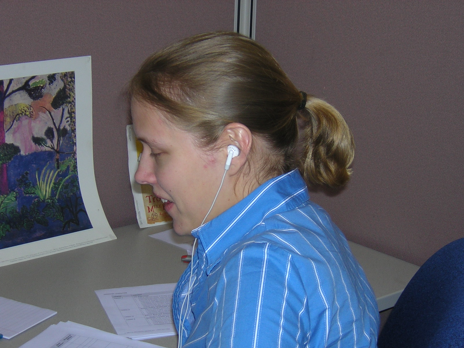 a woman looking back while sitting at a desk