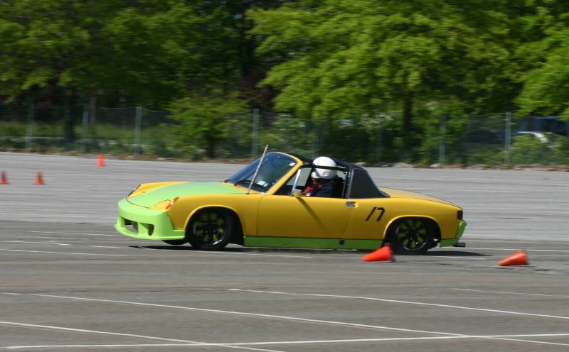 the car is driving through an orange cone on a race track