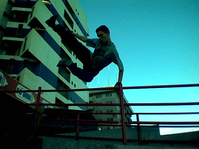 skateboarder performing aerial trick near railing in urban area
