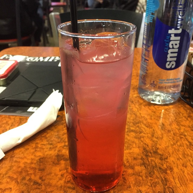 an iced drink on a table in front of water bottles