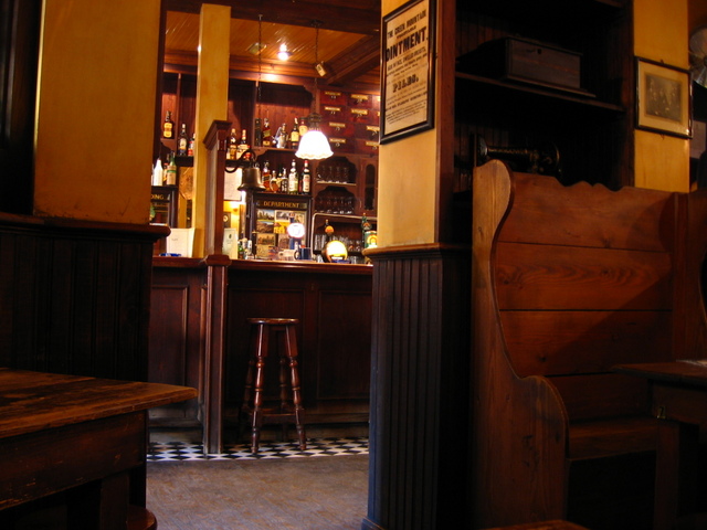 a small bar with stools in it and many bottles