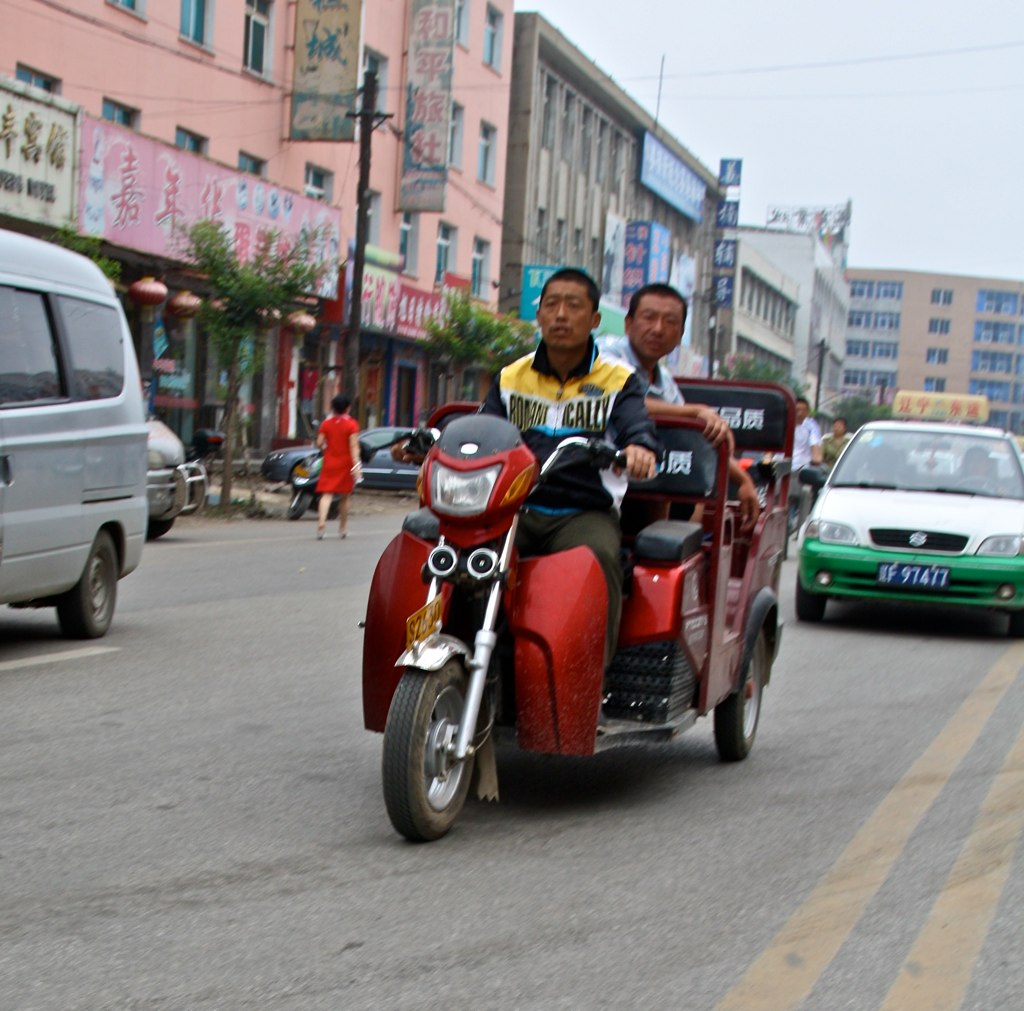 an image of two men riding a motorcycle