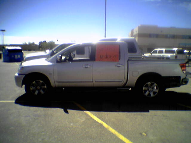 an orange and white pickup truck parked in a parking lot