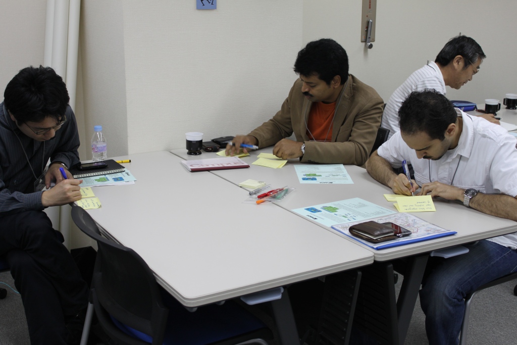 three people at a meeting writing on notebooks